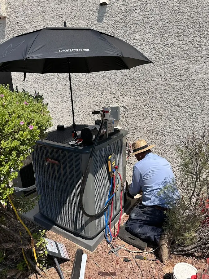HVAC technician performing outdoor AC maintenance in Pueblo