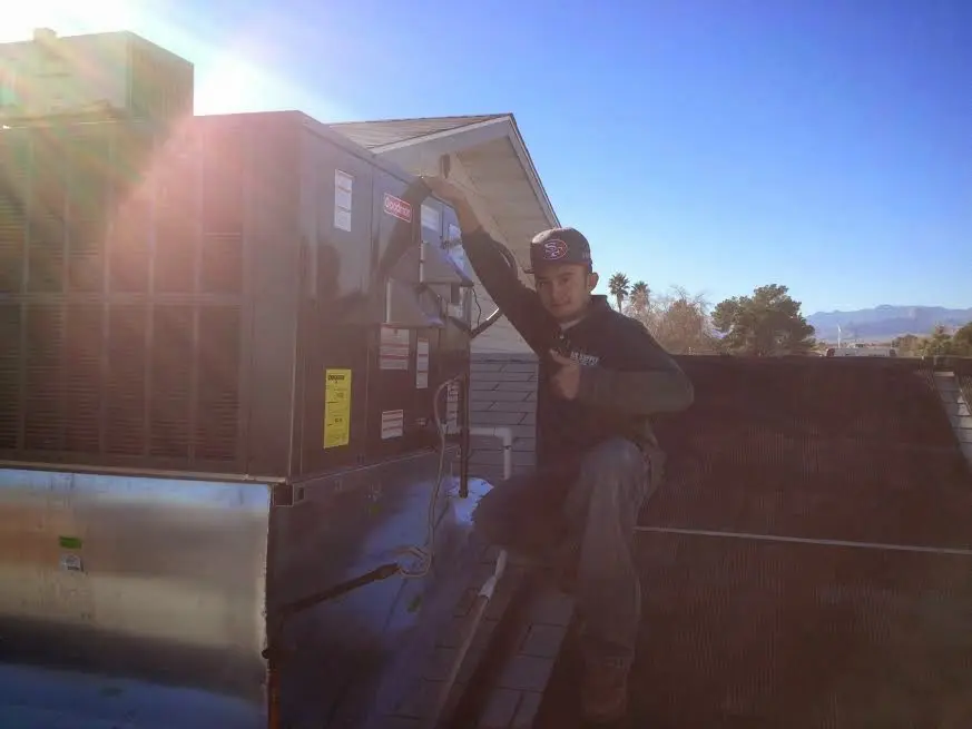 HVAC technician performing AC Tune-Up on a rooftop unit in Pueblo